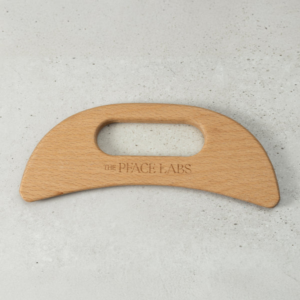 Wooden tool with 'The Peace Labs' branding on a light gray background